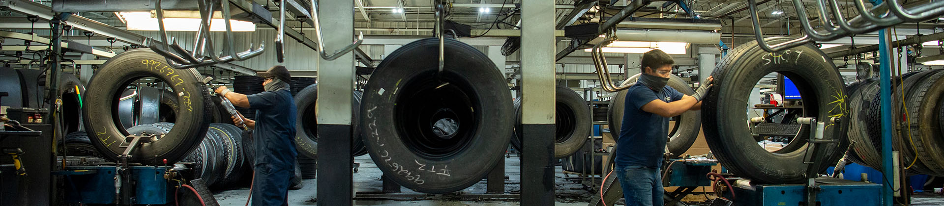 two mechanics retread tires opposite of each other