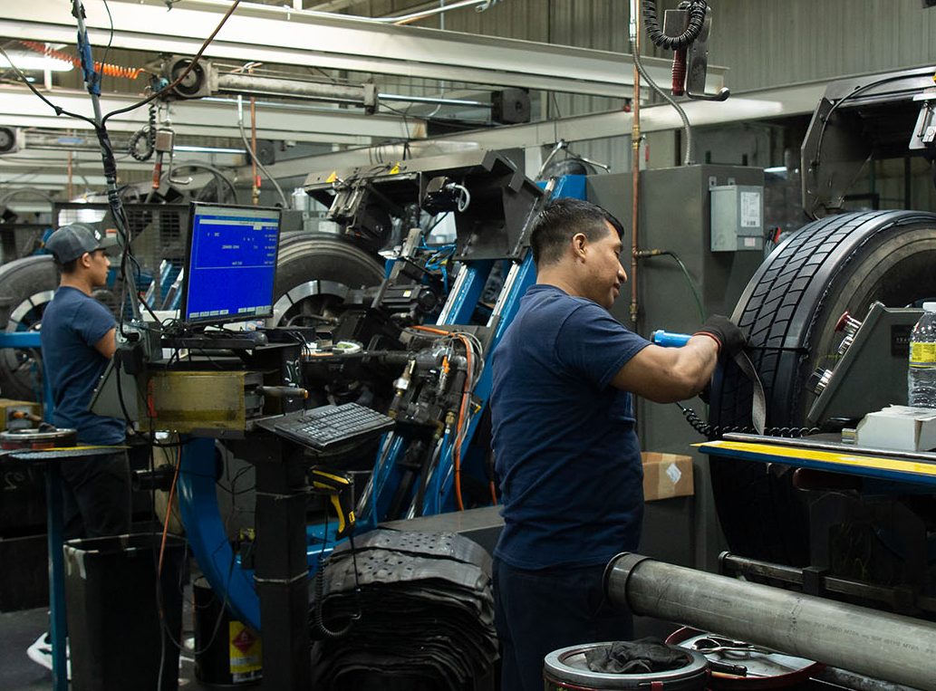 workers retreading tires to help your money and tires