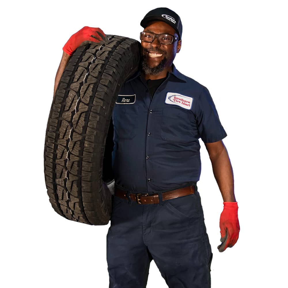 mechanic smiling holding a tire